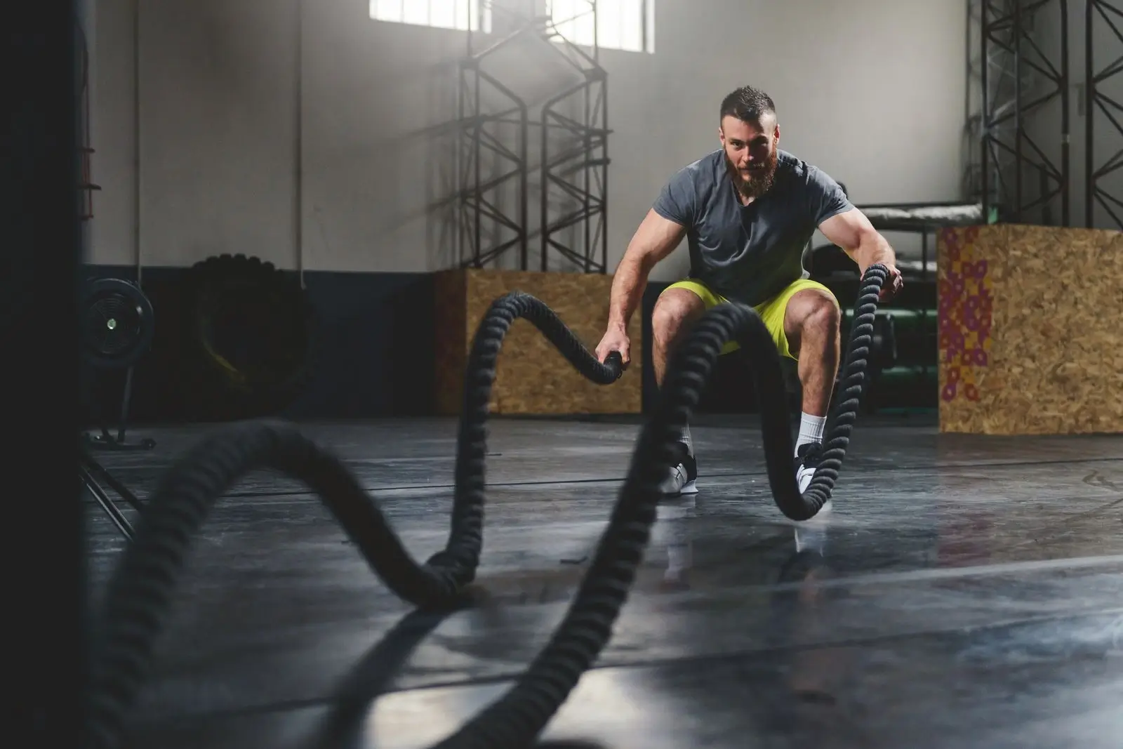 Man performing a powerful exercise with battle ropes